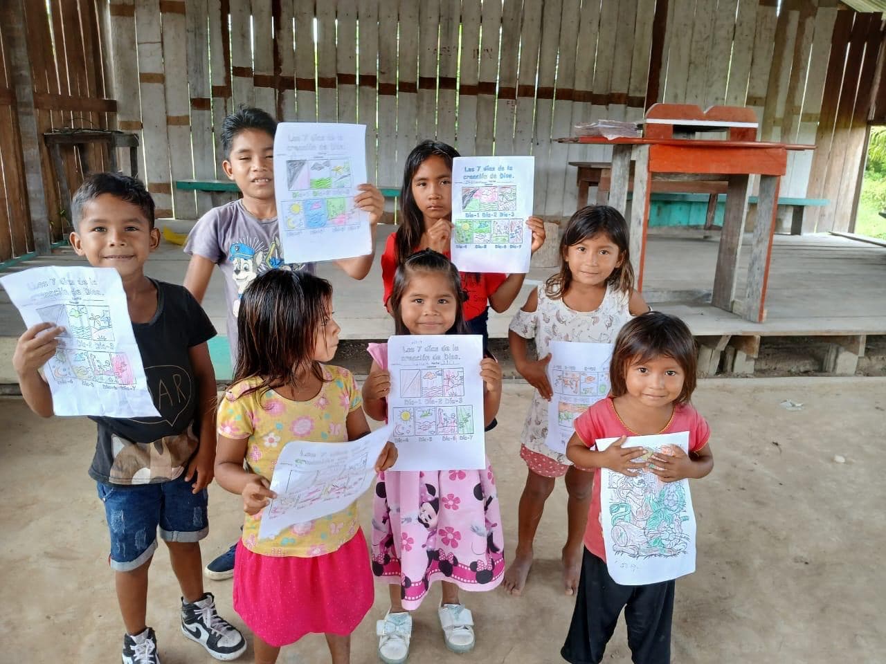 Children proudly holding up their drawings